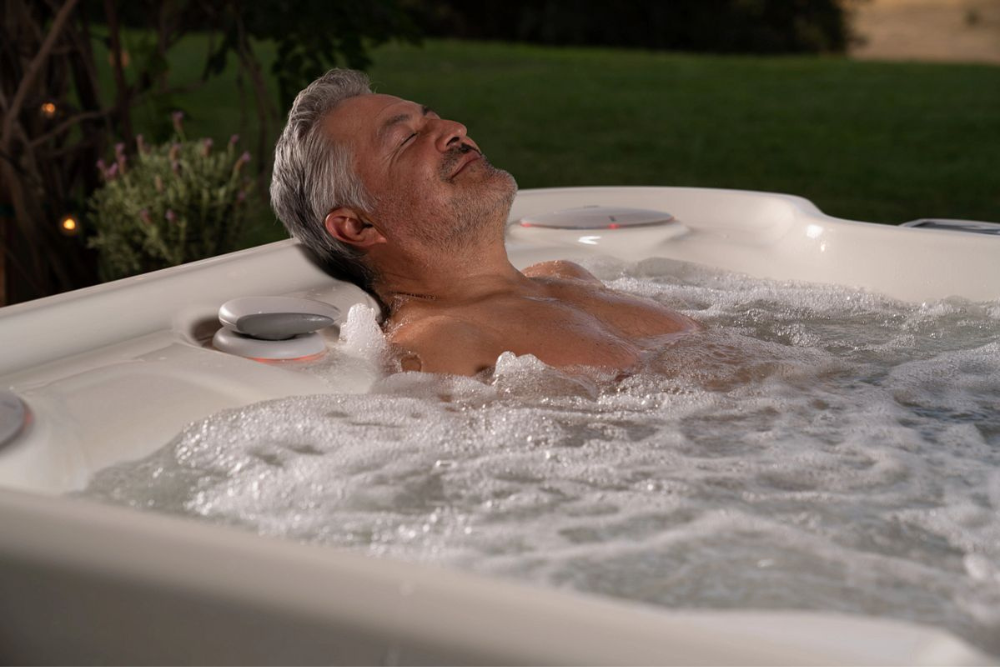 Man in HotSpring® hot tub. Capital Hot Tubs explains the benefits of Saltwater hot tubs.